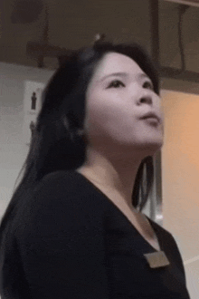 a woman in a black shirt with a name tag on her neck