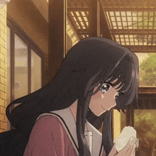 a girl with long black hair holds a piece of paper in her hand