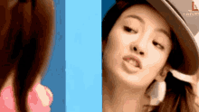 a woman in a hat is looking at herself in a mirror