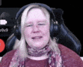 a woman wearing headphones is sitting in a chair and smiling .