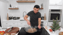 a man is stirring food in a wok with a wooden spoon in a kitchen with the words made in animatica below him