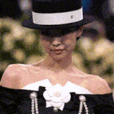 a woman wearing a black top hat and a black dress