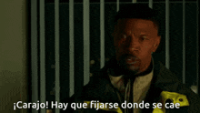 a man with a beard is standing in front of a window and says carajo hay que fijarse donde se cae .