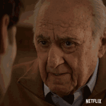 a close up of an older man 's face with a netflix logo on the bottom