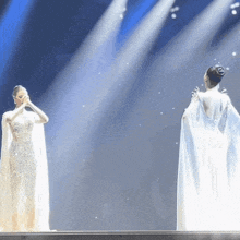 a woman in a white dress stands next to another woman in a white dress
