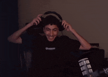 a man wearing headphones and a shirt that says souvenir is smiling