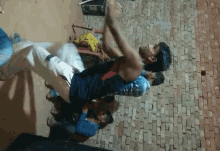 a group of young men are dancing in a room with a brick wall in the background