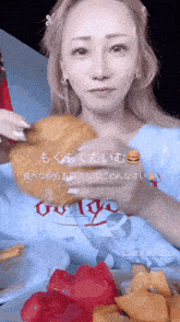 a woman is eating a croissant with a hamburger in the background in a foreign language