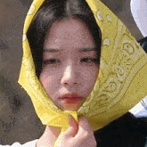 a woman wearing a yellow bandana on her head with the letter s on it