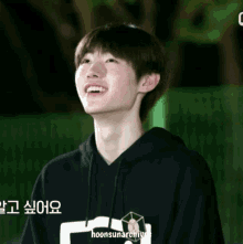 a young man wearing a black hoodie with the words hoonsunarchives written on the bottom