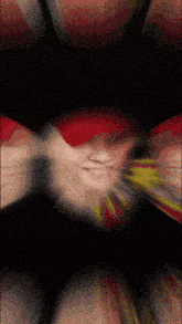 a blurred image of a person 's face with a red hat on