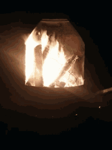 a fire is burning in a fireplace in a dark room