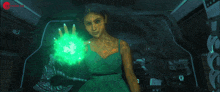 a woman in a green dress holds a green object