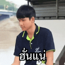 a young man wearing a blue shirt with a green collar and sleeves has a sticker on his shirt that says gs