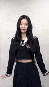 a girl with long black hair is wearing a sailor uniform .