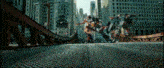 a group of transformers standing on top of a bridge in a city .