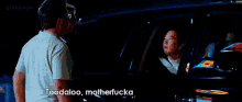 a man standing next to another man in a car with the words toodaloo motherfucka written on the screen