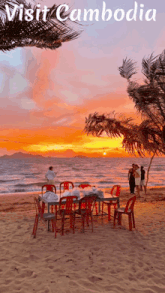 a poster for cambodia shows a sunset and a table and chairs on the beach