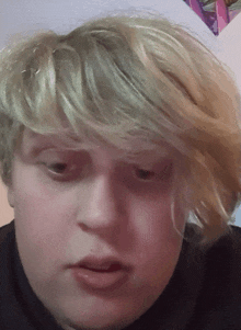 a close up of a person with blonde hair making a funny face