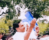 a man in a white shirt is holding a blue book that says ' freedom ' on the cover
