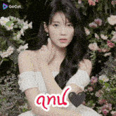 a woman in a white dress is surrounded by flowers and the word gocut is on the bottom left