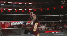 a wrestler is jumping over a rope in a ring while wearing a mask .
