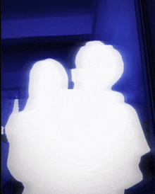 a silhouette of two people standing next to each other against a blue background