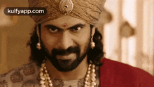 a man with a beard wearing a turban and a necklace .