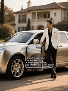 a man in a suit stands next to a silver car