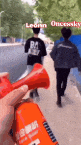 a man in a black shirt that says bad ally is walking down the street