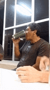 a man drinking from a green bottle with the word nike on his shirt