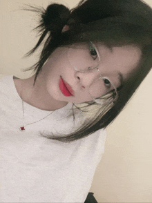 a girl wearing glasses and a necklace with a red pendant