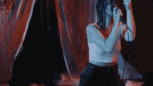 a woman singing into a microphone with her hair wet