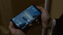 a person is holding a cell phone with a screen that says 10:10