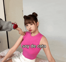 a woman wearing a pink tank top with the words soy de cata written on it