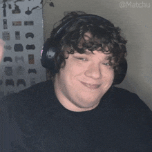 a man with curly hair wearing headphones with the hashtag matchu on the bottom right