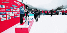 a group of people standing on a podium in front of a wall that has hylo written on it