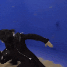 a person in a black suit is running in front of a blue background