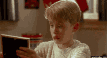 a young boy looking at a picture with the website woofmaker.com visible