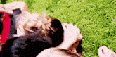 a man and a woman are laying on the grass .