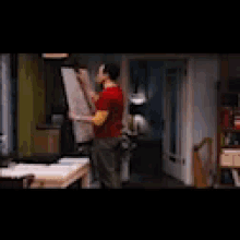 a man in a red shirt is holding a large piece of paper