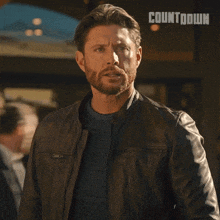 a man in a leather jacket stands in front of a sign that reads countdown