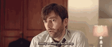 a man with a beard is sitting at a table talking to someone .