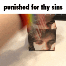 a cube with a picture of a man on it and the words punished for thy sins