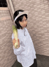 a woman wearing a helmet and a white shirt holds a banana