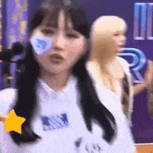 a woman with a star on her shirt is dancing in front of a purple wall .