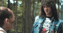 a man wearing a t-shirt that says lfi club talks to a girl