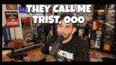 a man talking into a microphone with the words " they call me trist ooo " above him