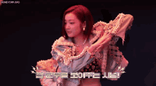 a woman with red hair is wearing a pearl covered jacket