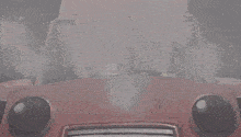 a cartoon character is driving a red car with a smiley face on the windshield